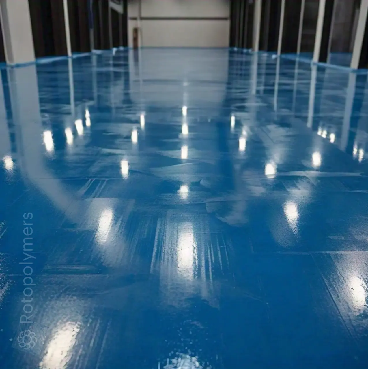 Glossy blue epoxy floor in a large industrial hall